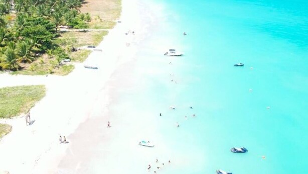 An aerial view of a beach with clear turquoise waters, a sandy shore, and several boats. - Ponta Village - Paradise in Maragogi - Cottage 02 (Maragogi)