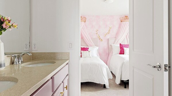 A bedroom with a double bed, a vanity with a mirror, and a sink. - Sleeps 26! Resort Home w/ On-site Waterpark, Pool Flamingo Grove by Avantstay (Davenport)