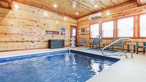 A wooden interior with a pool, chairs, and a lifebuoy.
