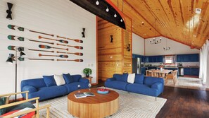 Ein modernes Wohnzimmer mit einem blauen Sofasitzgruppe, einem Holztisch und einer Wand mit Holzschlägern.