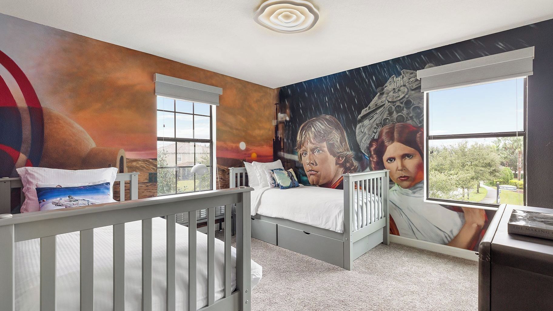 Una camera da letto con una culla, un letto e un grande affresco al muro.