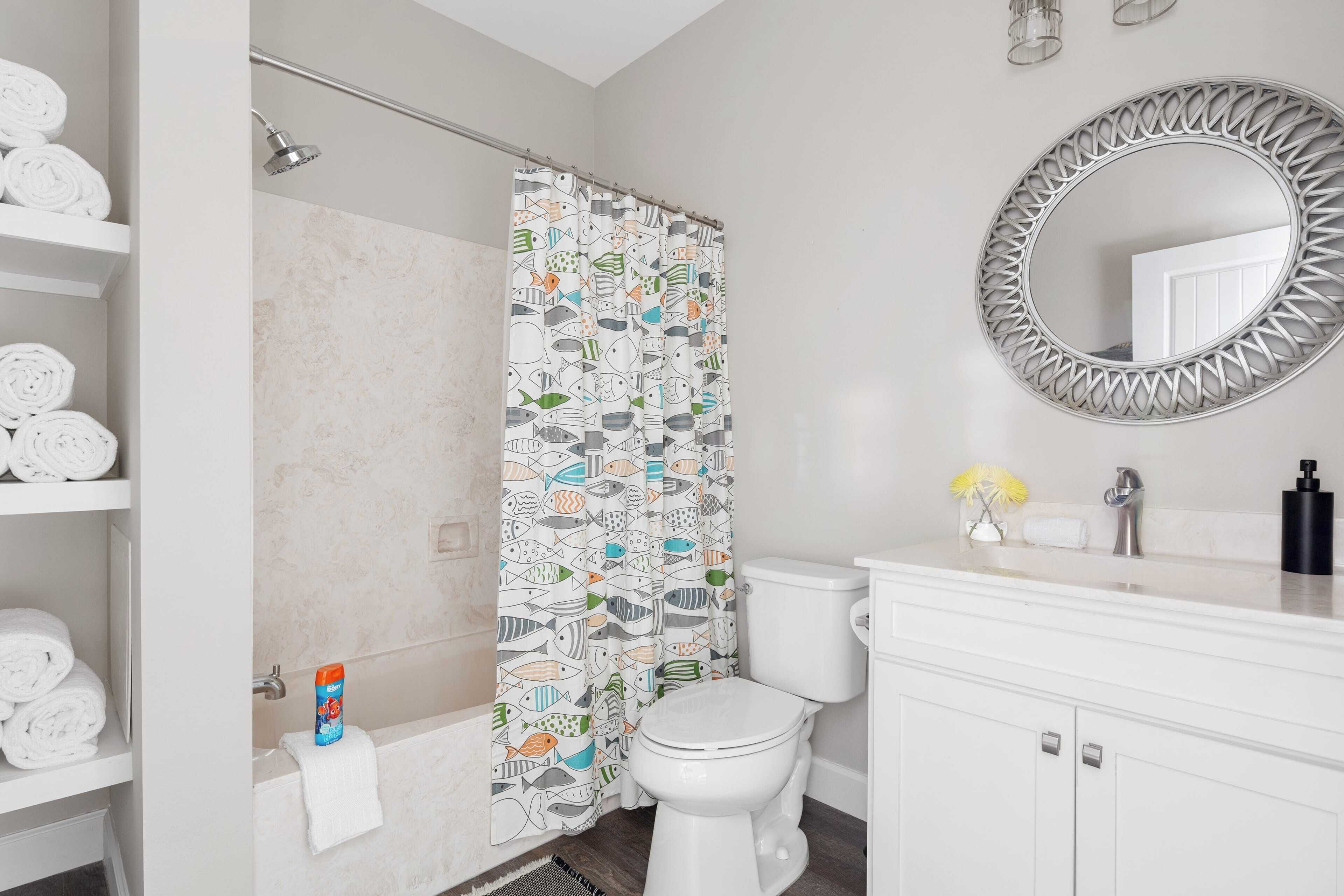 A bathroom with a shower, toilet, and sink.