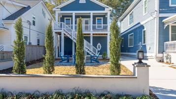 A two-story house with a balcony, a front porch, and a small deck area.