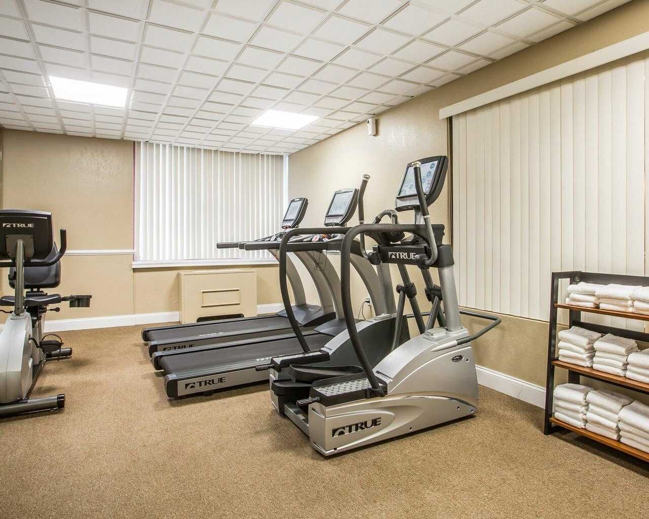 Un centre de remise en forme équipé de tapis de course, d’un vélo d’appartement et d’un appareil d’aviron.