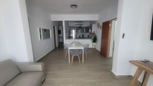 A modern apartment with a dining area, kitchen, and living space.