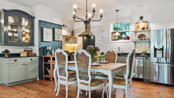 A spacious kitchen with a dining area, wooden floors, and modern appliances.