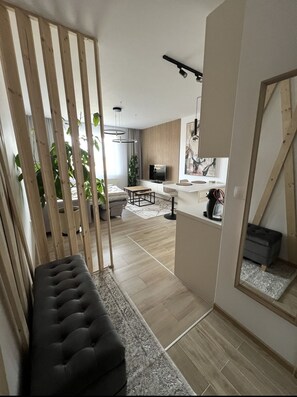 Een moderne woonkamer met een bank, een eethoek en een keuken.