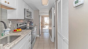 Een moderne keuken met witte kastjes, een roestvrijstalen fornuis en een inbouwmagnetron.