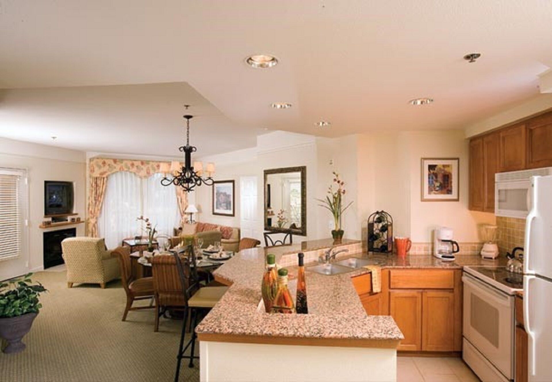 A modern kitchen with granite countertops, a central island, and wooden cabinets.