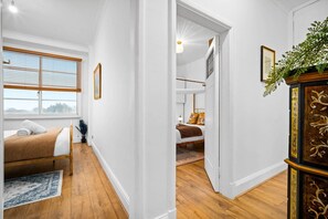 Relax in a serene space with a comfortable bed, a stylish cabinet, and a potted plant.