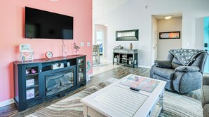 Een woonkamer met een flatscreen televisie, een open haard, een bank en een salontafel.