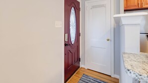 Una cocina con refrigerador blanco, armarios de madera y encimera de granito.