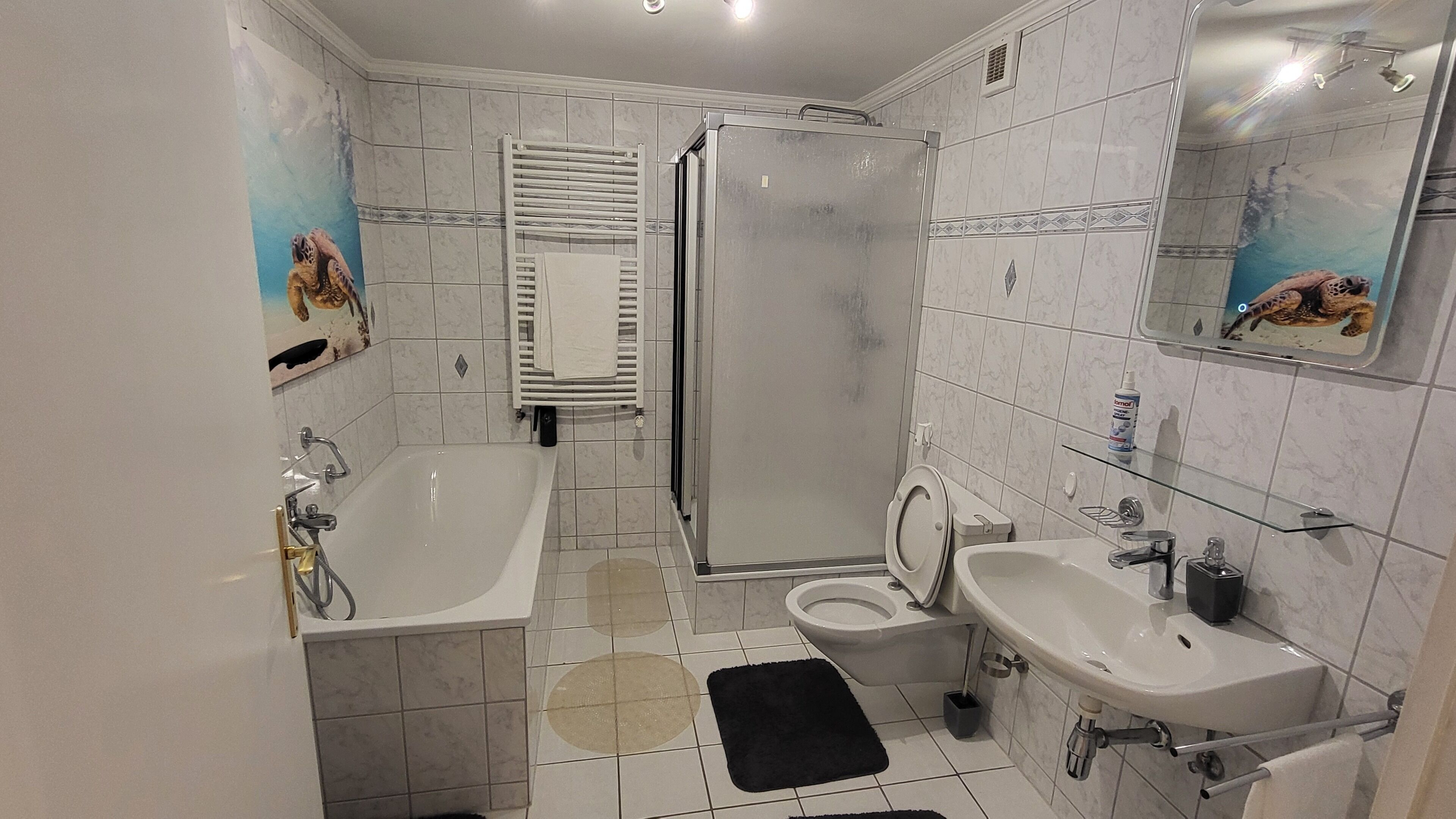 Een badkamer met een bad, douche, toilet en wastafel.