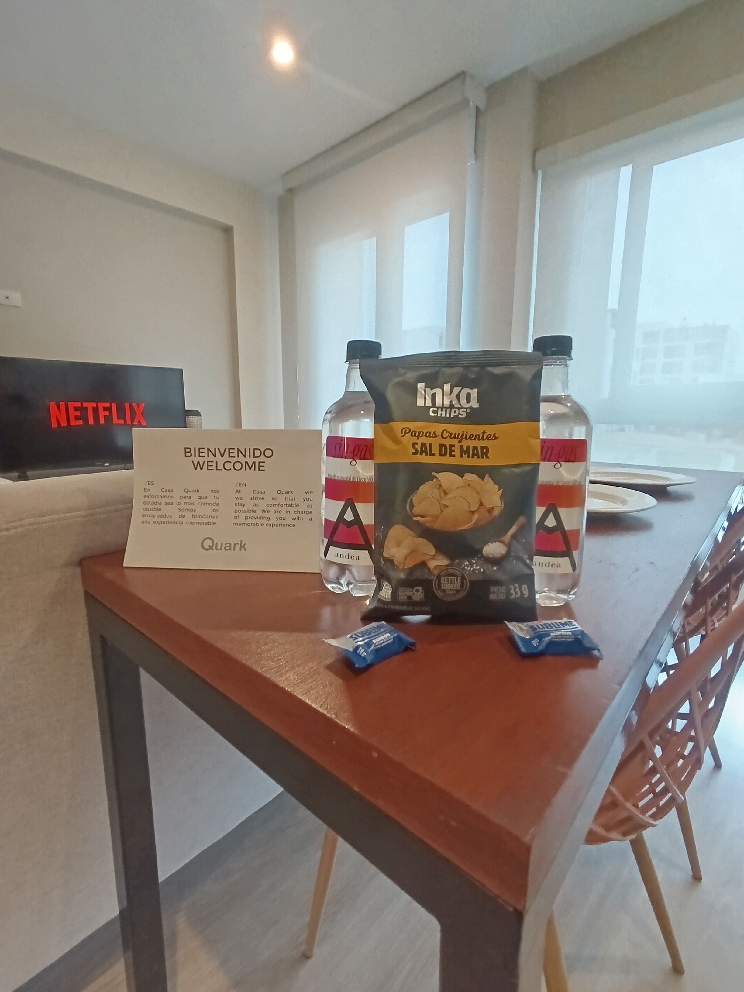 A welcome sign, a table with snacks, a bottle, and a Netflix sign in a room.