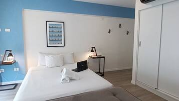 Hotelkamer met een groot bed, een bureau, een stoel, een kledingkast en een wandairconditioner.