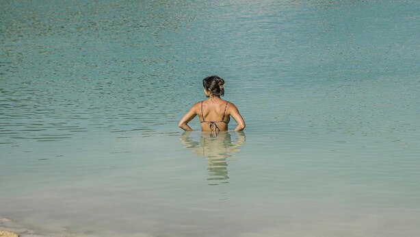 A person standing in calm water. - Pine Tiny House Rental (Bandera)