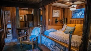 A cozy room with a stone wall bed, a wooden chair with a blue towel, and a rustic wooden floor. - Historic Cowboy Retreat • Sleeps 4 • Wooded Hills Near Temecula (Temecula)