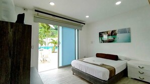 A bedroom with a bed, a nightstand, a window with a view of the outdoors, and a ceiling fan. - HOTEL KAAMU TAGANGA (Santa Marta)