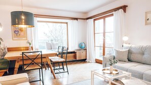 Un salon moderne avec une table à manger en bois, des chaises, un canapé et une table basse.