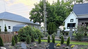 Un patio de grava con sillas Adirondack y una chimenea.