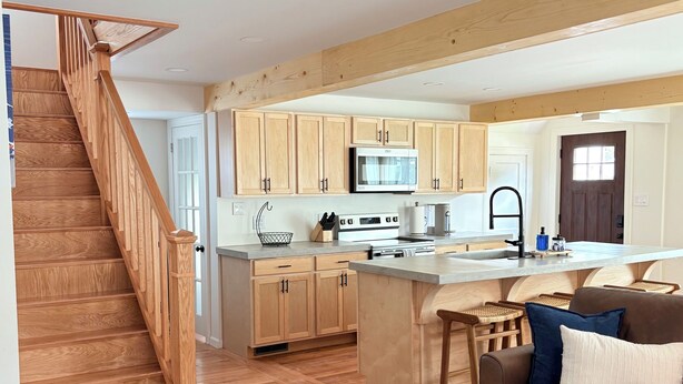 Una cocina moderna con armarios de madera, una isla central y un horno empotrado.