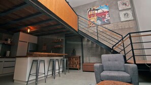 Eine moderne Küche mit Holzbalkendecke, einer Bar und einer Treppe zu einer oberen Ebene.