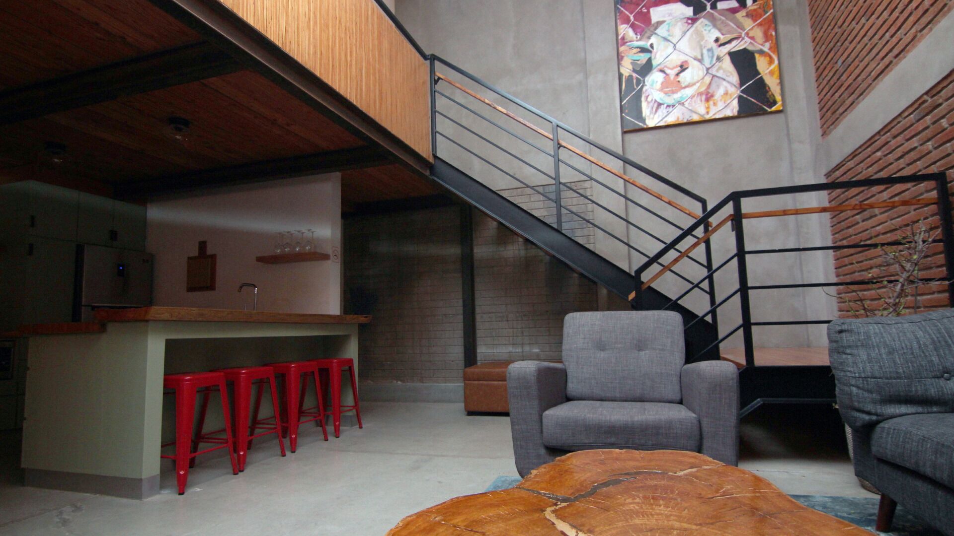 Un interior moderno con cocina, una escalera y zona de estar.