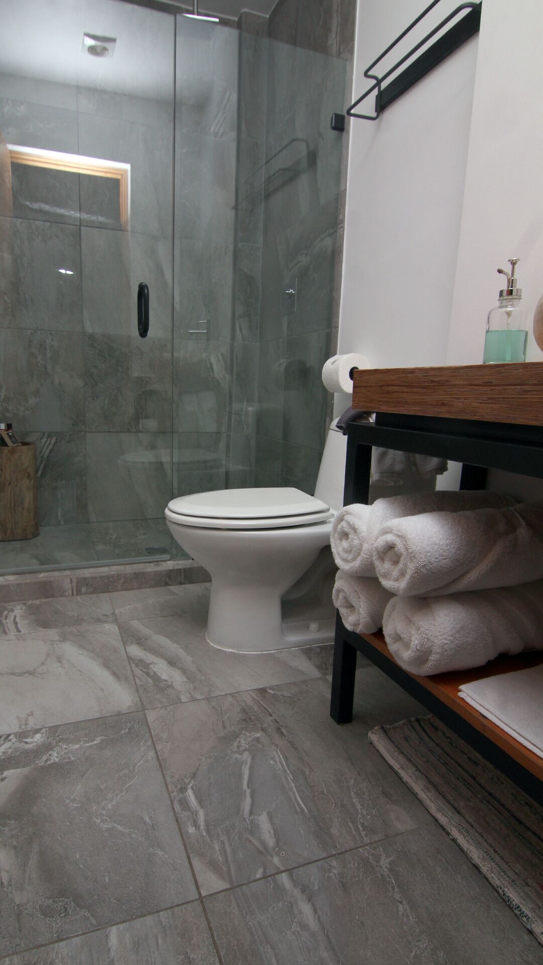 Deluxe studio | Badkamer | Een douche, een haardroger, handdoeken, zeep