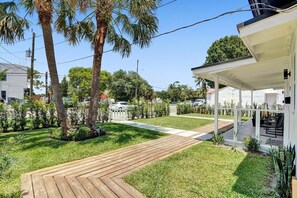 A modern house with a wooden deck, a covered patio, and a well-maintained lawn. - Modern Hallandale Apt w/ Backyard Near Beach (Hallandale Beach)