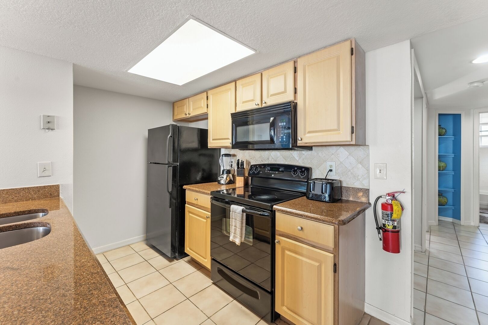 Una cocina moderna equipada con refrigerador, microondas, estufa y tostadora.