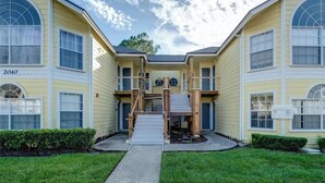 A two-story building with a central staircase, large windows, and a number '2040' on the left facade. - 3-br Condo Near Disney Family-friendly Retreat (Kissimmee)