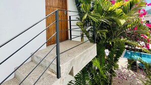 A white building with a wooden door and a sign that reads "SOL". - Huge Suite!! King Bed, A/C, Saltwater Pool, Fast Wifi, Mountain Views -"Sol" (San Francisco)