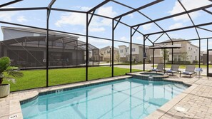A swimming pool with a glass enclosure, a hot tub, and lounge chairs. - Sleeps 25! In Solara Resort, Near the Theme Parks Coconut Breeze by Avantstay (Kissimmee)