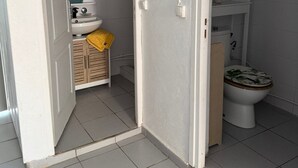 Une salle de bain avec des toilettes, un lavabo et des meubles en bois.