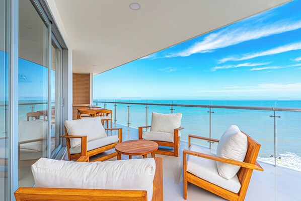 A balcony with wooden furniture and a view of the ocean. - Cartagena Dreams (Cartagena)