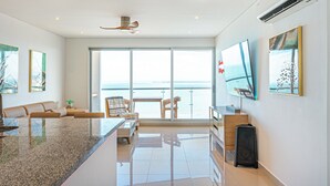 A modern kitchen with a granite countertop, a dining area with a table and chairs, and a large TV on the wall. - Cartagena Dreams (Cartagena)