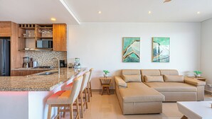 A modern kitchen with granite countertops, wooden cabinets, and a central island with bar stools. - Cartagena Dreams (Cartagena)