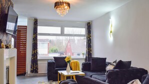 A modern living room with a black sofa set, a yellow accent table, and a chandelier. - 3 bedroom accommodation in Ashton on Ribble, near Preston (Ashton on Ribble, near Preston)