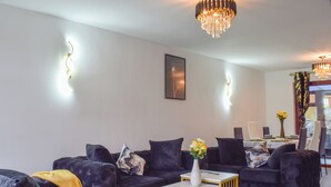 A modern living room with dark sofas, a coffee table, and a chandelier. - 3 bedroom accommodation in Ashton on Ribble, near Preston (Ashton on Ribble, near Preston)