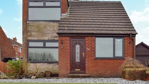 A two-story house with a brick facade, a dark brown door, and a small front garden with gravel and grass. - 3 bedroom accommodation in Ashton on Ribble, near Preston (Ashton on Ribble, near Preston)