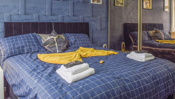 A bedroom with a large bed, a headboard, and a mirror. - 3 bedroom accommodation in Ashton on Ribble, near Preston (Ashton on Ribble, near Preston)