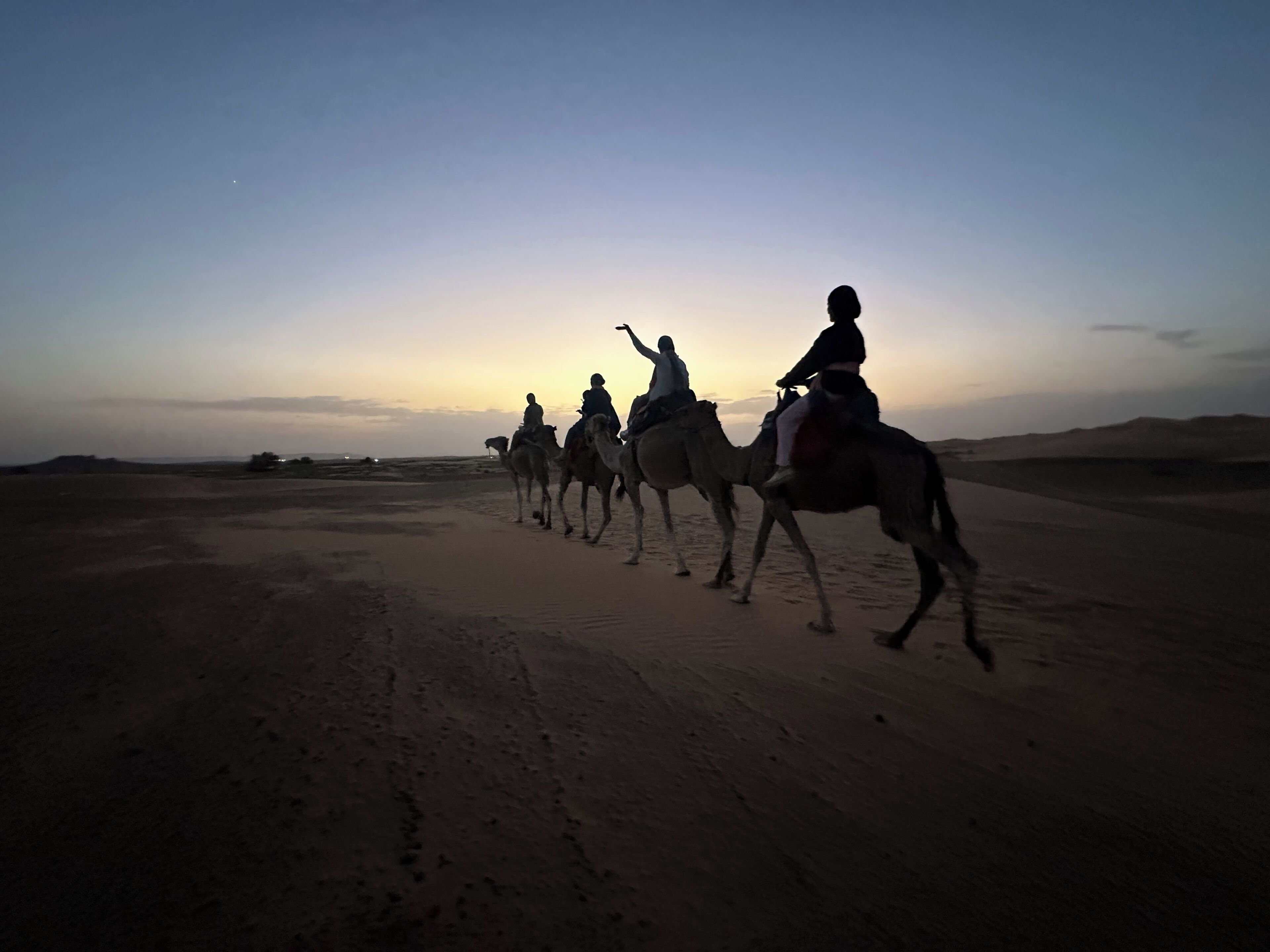 A desert landscape with a clear sky at dusk.