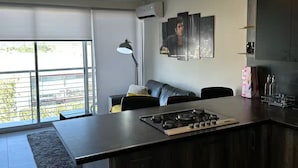 A modern kitchen with a central island, dark cabinetry, and a pendant light fixture. - Luxury Apartment Fracc Element (San Agustín)