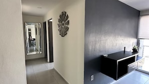 A modern kitchen with a black countertop and a decorative wall piece. - Luxury Apartment Fracc Element (San Agustín)