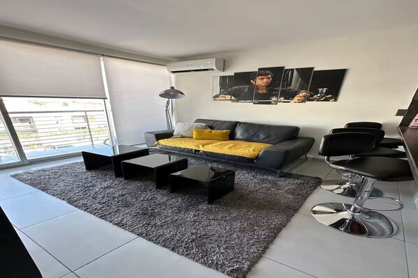 Una sala de estar moderna con un sofá, una mesita de centro y una zona de bar.
