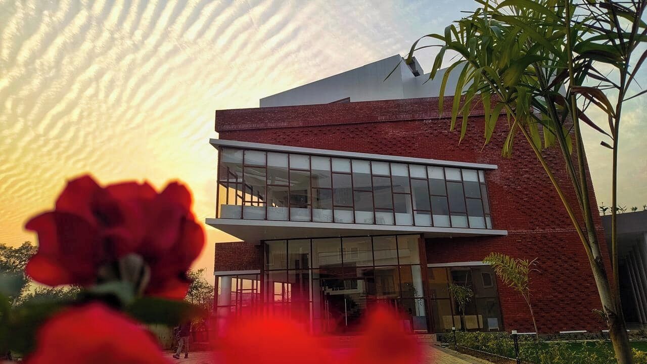 A modern building with a glass facade and a brick lower section.