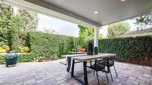 An outdoor patio with a table and chairs, a grill, and a potted plant. - Eastside Costa Mesa Home Walking Distance to Back Bay Newport Beach (Costa Mesa)