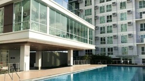 Um edifício moderno com piscina, janelas amplas e aparelhos de ar condicionado.