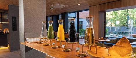 Zona de bar con diferentes dispensadores de bebidas y asientos.