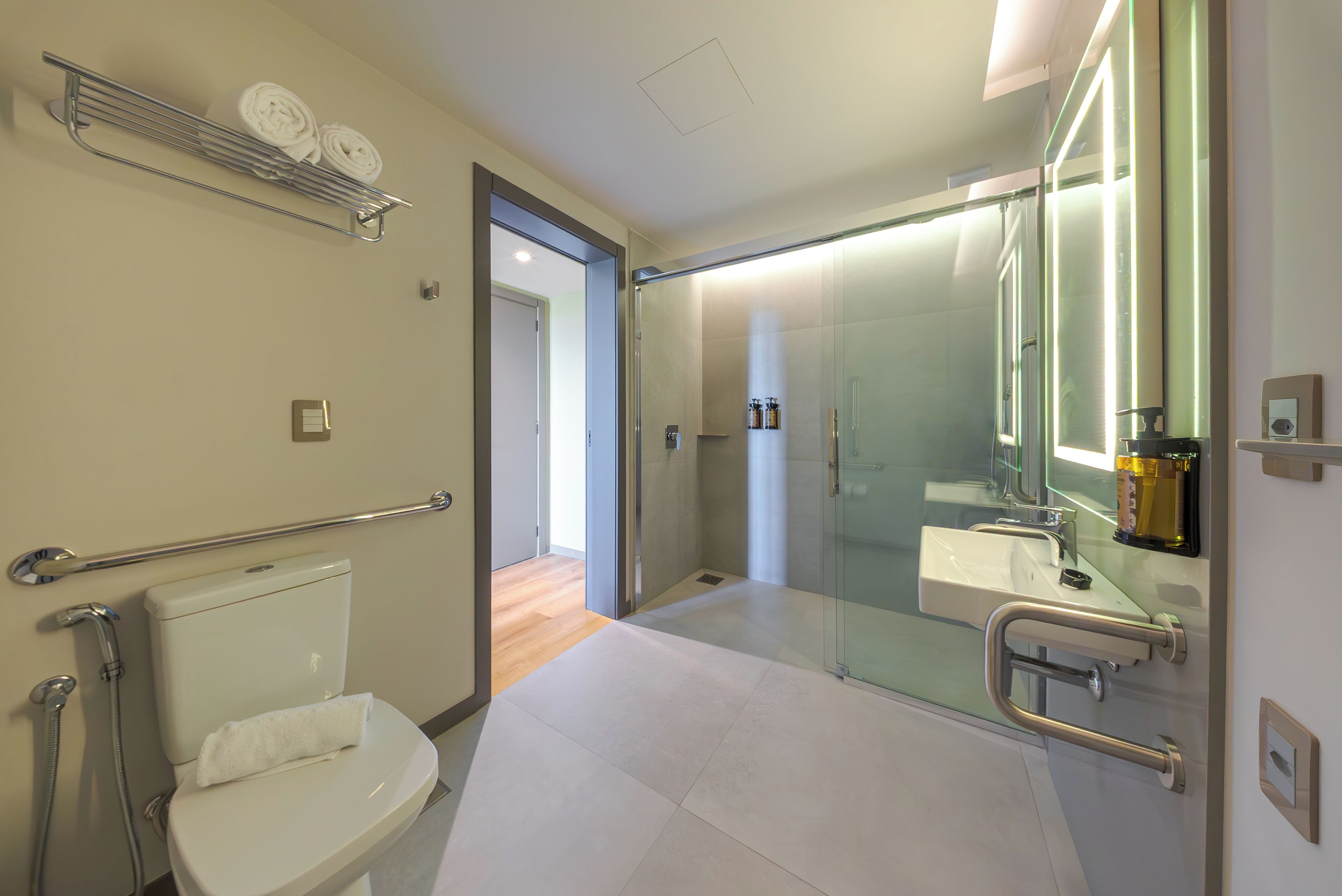 Un bagno moderno con toilette, doccia e cabina doccia in vetro.